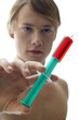 A shirtless man holding a syringe.