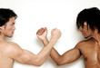 Foto: A shirtless muscular african american man and man arm wrestling. A shirtless muscular african american man and man arm wrestling.