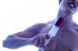 A shirtless man injecting his neck with a syringe.
