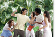 A guy tring to beat up a african american guy while their girlfriends holding them back.