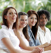 Three ladies and a african american man sitting in a row.