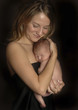 a woman holding her baby close to her body.