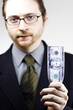 a bespectacled man in business suit holding a banknote.