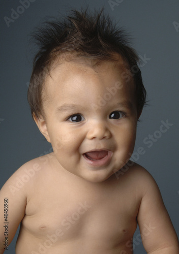 Photo: a baby boy with messy hair smiling. a baby boy with messy hair smiling.