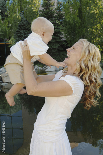 Photo: a woman lifting up a baby. a woman lifting up a baby.
