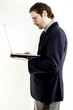 Photo: side shot of a bespectacled man in business suit placing a laptop on his palm. side shot of a bespectacled man in business suit placing a laptop on his palm.