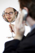 Photo: back shot of a man looking at a mirror he is holding while talking on the handphone. back shot of a man looking at a mirror he is holding while talking on the handphone.