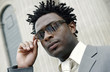 A african american man in business suit adjusting his sunglasses.