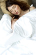 a woman covered with blanket sleeping on the bed.