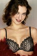 Photo: A female model in black and white bra holding red feathers and flashing a smile at the camera. A female model in black and white bra holding red feathers and flashing a smile at the camera.