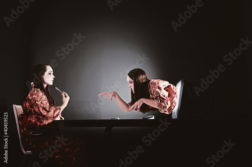 Photo: a lady in applying makeup while a ghost crawling out from the computer screen. a lady in applying makeup while a ghost crawling out from the computer screen.