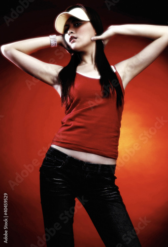 Photo: A studio shot of a lady in casual wear and cap. A studio shot of a lady in casual wear and cap.
