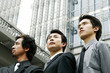Three businessmen standing in front of the building. 