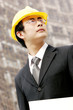 Photo: A man with safety helmet at a construction site. A man with safety helmet at a construction site.