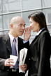 Foto: A woman whispering something to a bald man. A woman whispering something to a bald man.