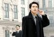 Foto: A bespectacled man talking on the handphone while another man talking using bluetooth. A bespectacled man talking on the handphone while another man talking using bluetooth.