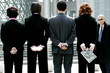 A baldman watching a group of business people standing in a row. 