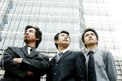 Foto: Three businessmen standing in front of the building. Three businessmen standing in front of the building.