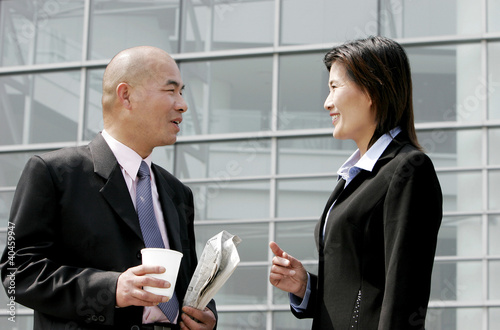Photo: A bald man talking to a woman. A bald man talking to a woman.