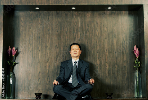 Photo: A man in business suit meditating. A man in business suit meditating.