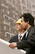 Architect discussing a building plan with his client at a construction site. 