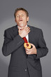 Man in business suit choked on a tart. 