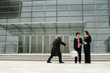 Bald man trying to snatch a business woman's briefcase. 