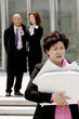 An angry woman carrying a briefcase of documents. 