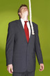 Man in business suit looking at a rope hanging from the top. 