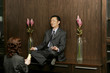 Woman worshipping a businessman who is sitting on the shelf meditating. 