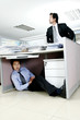 Man trying to find his worker who is sleeping under the desk. 