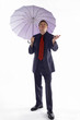 Photo: Man in business suit holding an umbrella while checking the weather. Man in business suit holding an umbrella while checking the weather.