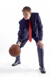 Man in business suit dribbling a basketball. 
