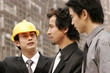 Architect discussing a building plan with his client at a construction site. 