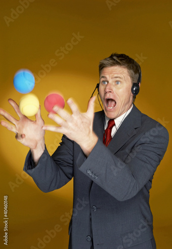 Photo: Man trying to juggle with three balls. Man trying to juggle with three balls.