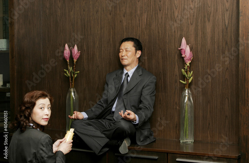 Photo: Woman worshipping a man who is sitting on the shelf meditating. Woman worshipping a man who is sitting on the shelf meditating.