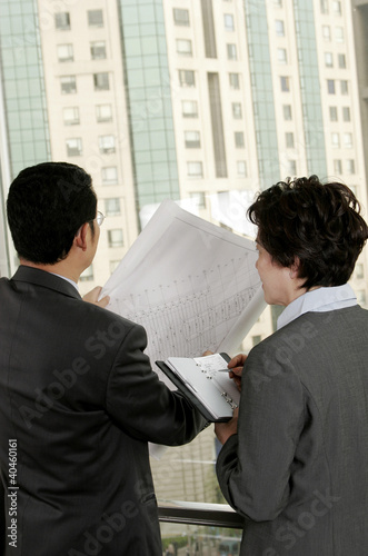 Photo: Businessman discussing a building plan with his assistant. Businessman discussing a building plan with his assistant.