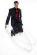 Man in business suit playing with skipping rope. 