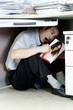 Man hiding under his desk reading pornographic magazine. 