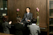 Women worshipping a businessman who is sitting on the shelf meditating. 