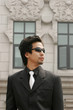 Businessman with sunglass standing in front of a building. 
