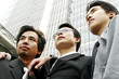 Low angle view of three businessmen standing in front of the building. 