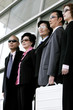 Business men and women in sunglasses standing in a row. 