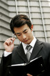 Photo: Businessman thinking of things to write on his organizer. Businessman thinking of things to write on his organizer.