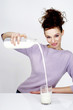 Woman pouring milk into a glass.