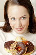 Woman holding a plate of doughnuts.