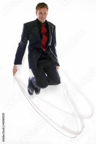 Photo: Man in business suit playing with skipping rope. Man in business suit playing with skipping rope.