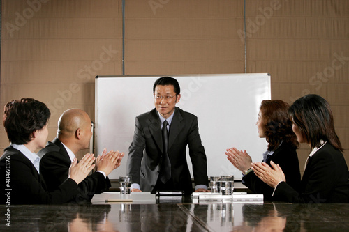 Photo: Business man and women clapping their hands after a good presentation. Business man and women clapping their hands after a good presentation.