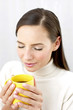 Woman smelling an aromatic cup of coffee.