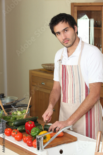 Photo: Man cutting vegetables on a chopping board Man cutting vegetables on a chopping board